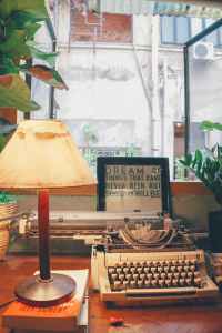 white typewriter beside table lamp